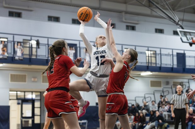 Oswego East's Cassie Van Meter (13) goes up for a layup against Yorkville during a Southwest Prairie Conference game in Oswego on Tuesday, Feb. 11, 2025. (Troy Stolt / for the Beacon News)