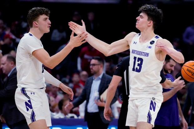 Northwestern forward Nick Martinelli, left, celebrates with guard Brooks Barnhizer after they defeated Wisconsin in an NCAA college basketball game in Evanston, Ill., Monday, Jan. 23, 2023. (AP Photo/Nam Y. Huh)