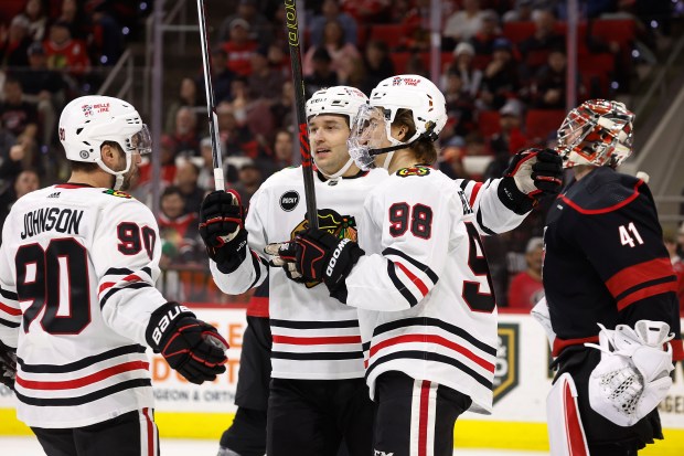 Chicago Blackhawks' Connor Bedard is congratulated on his goal by teammates during the third period of an NHL hockey game against the Carolina Hurricanes in Raleigh, N.C., Monday, Feb. 19, 2024. (AP Photo/Karl B DeBlaker)