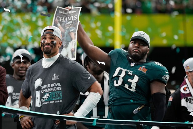 Eagles quarterback Jalen Hurts, left, smiles on the podium next to defensive tackle Milton Williams after a win over the Chiefs in the Super Bowl on Sunday, Feb. 9, 2025, in New Orleans. (AP Photo/Matt Slocum)