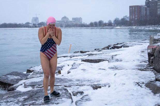 Qing Li comes out of the water after swimming at Burnham Park Promontory Point at sunrise in Chicago on Feb. 16, 2025. The water was 31.8 degrees Fahrenheit, according to a year-round swimmer, Bill Stamets, who measures the temperature every morning. (Audrey Richardson/Chicago Tribune)