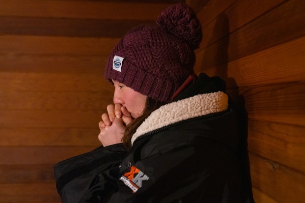 Qing Li warms up at her apartment's sauna after swimming at Burnham Park Promontory Point at sunrise in Chicago on Feb. 16, 2025. Li goes into the sauna with multiple layers, including her snow pants to help the warming process after jumping in near-freezing waters. "The rewarming process is the toughest part for people," she said. (Audrey Richardson/Chicago Tribune)