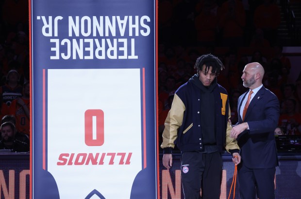 Former Illinois basketball player Terrence Shannon Jr. stands next to athletic director Josh Whitman, right, as a banner displaying his jersey and name is unveiled during a halftime ceremony Saturday, Feb. 15, 2025, in Champaign. The banner was mistakenly unveiled upside down. (John J. Kim/Chicago Tribune)