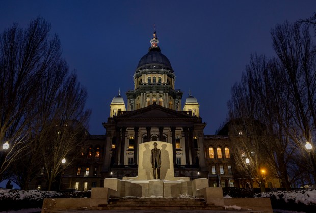 Dusk falls in the snow on the Illinois State Capitol behind an Abraham Lincoln statue on Jan. 7, 2025, in Springfield. (Brian Cassella/Chicago Tribune)