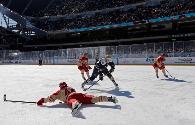 Miami Steven Spinell (44) falls to the ice with the puck as Notre Dame Steven Fogarty (26) looks on in the second period of the OfficeMax Hockey City Classic played at Soldier Field in Chicago on Sunday, Feb. 17, 2013. (José M. Osorio/ Chicago Tribune) B582725223Z.1 ....OUTSIDE TRIBUNE CO.- NO MAGS, NO SALES, NO INTERNET, NO TV, NEW YORK TIMES OUT, CHICAGO OUT, NO DIGITAL MANIPULATION...