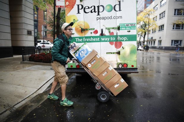 Ozzie Castrejon, a Peapod delivery worker, prepares a delivery for a client in Chicago on Oct. 24, 2017. (José M. Osorio/Chicago Tribune)