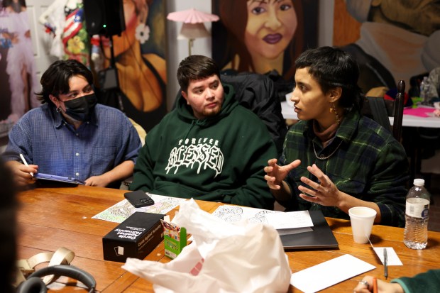 Jai Perez, right, speaks to Tichike, left, and Santiago Troncoso during a gender-affirming haircut event at the TransChicago Empowerment Center in Humboldt Park on Feb. 10, 2025. Staffers Tichike and Jai were laid off after the CDC terminated two grants previously awarded to the center. (Eileen T. Meslar/Chicago Tribune)