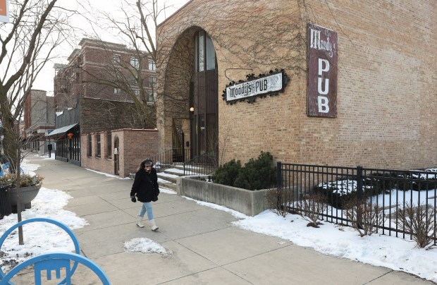 A woman walks past Moody's Pub in the 5900 block of North Broadway, Feb. 19, 2025, in Chicago. (John J. Kim/Chicago Tribune)