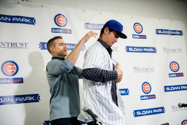 Cubs president Theo Epstein puts a jersey on newly signed Cubs pitcher Yu Darvish while attending a press conference at Sloan Park during Cubs spring training Tuesday Feb. 13, 2018, in Mesa, Ariz. (Armando L. Sanchez/Chicago Tribune)