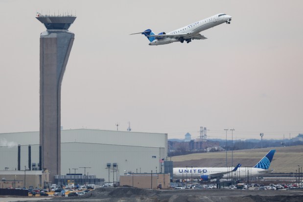 A United jet flies past the North Air Traffic Control Tower at O'Hare International Airport on Feb. 5, 2025. (Audrey Richardson/Chicago Tribune)