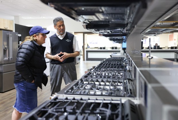 Salesman Harun Patel shows Lisa Singer, of Skokie, some of the features on a double oven at ABT Electronics on Feb. 5, 2025, in Glenview. (Stacey Wescott/Chicago Tribune)