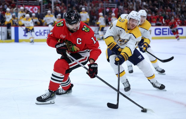 Chicago Blackhawks left wing Nick Foligno (17) and Nashville Predators center Gustav Nyquist (14) battle for the puck in the first period of a game at the United Center in Chicago on Feb. 7, 2025. (Chris Sweda/Chicago Tribune)