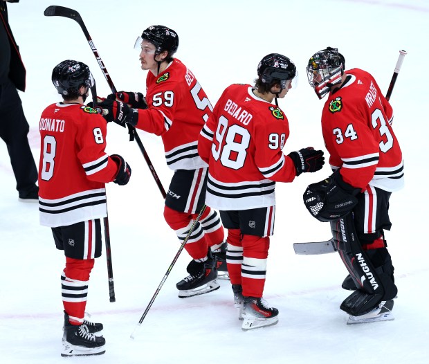 Chicago Blackhawks center Ryan Donato (8), left wing Tyler Bertuzzi (59), center Connor Bedard (98), and goaltender Petr Mrazek (34), celebrate after a victory over the Nashville Predators at the United Center in Chicago on Feb. 7, 2025. (Chris Sweda/Chicago Tribune)