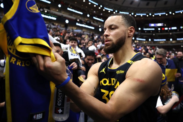 Golden State Warriors guard Stephen Curry (30) signs autographs for fans after a victory over the Chicago Bulls at the United Center in Chicago on Feb. 8, 2025. (Chris Sweda/Chicago Tribune)