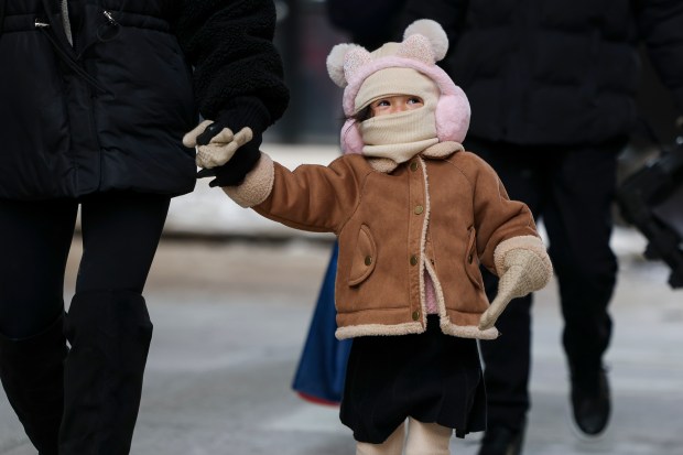 Kleah Nguyen, of San Diego, walks with her family in the Loop despite frigid temperatures on Feb. 17, 2025. (Eileen T. Meslar/Chicago Tribune)