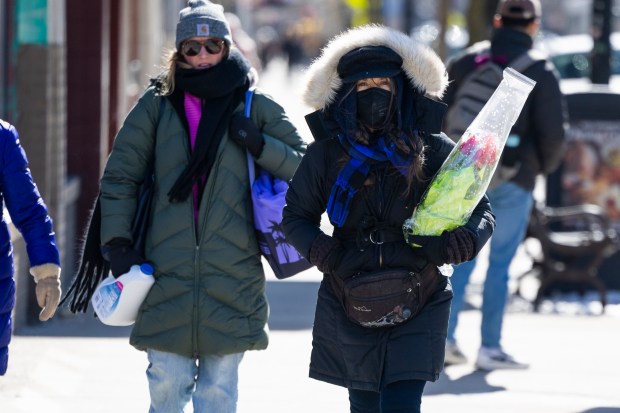 People brave cold temperatures as they cross Belmont Avenue in Lake View on Feb. 18, 2025. (Eileen T. Meslar/Chicago Tribune)