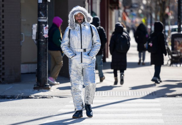 Ethan Kirschbaum wears a snowsuit to brave cold temperatures as he crosses Belmont Avenue in Lake View on Feb. 18, 2025. (Eileen T. Meslar/Chicago Tribune)