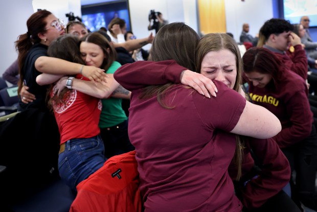 Brittany De Leon, center-right, and Olivia Goldstein, both 2nd and 3rd grade teachers at Acero's Santiago Elementary, embrace after the Chicago Public Schools board voted to keep open a number of Acero schools while keeping open two others through the 2025-2026 school year. The vote took place at CPS Headquarters on Feb. 27, 2025. Santiago is one of the schools to be kept open. (Chris Sweda/Chicago Tribune)