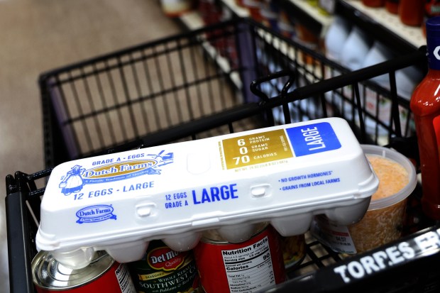 Box of a dozen Grade A large eggs sits in a shopping cart at Torres Market in Berwyn on Jan. 28, 2025. (Antonio Perez/Chicago Tribune)