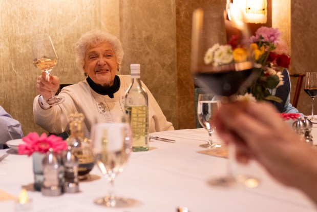 Sanna Longden, 87, cheers partnet Clint Seely, 83, during her 87th birthday dinner at The Mather in Evanston on Jan. 21, 2025. (Audrey Richardson/Chicago Tribune)