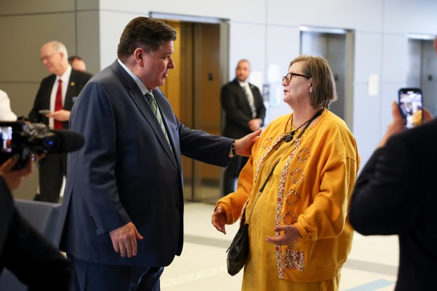 Gov. J.B. Pritzker speaks to Kristina Lewis, a longtime Medicaid recipient, after a press conference at the UI Health Mile Square Health Center on Feb. 28, 2025, discussing the impact of planned cuts to Medicaid health coverage. (Eileen T. Meslar/Chicago Tribune)