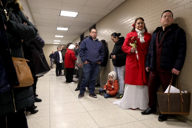 Dozens of couples wait in line with family and friends to exchange wedding vows on Valentine's Day at City Hall in Chicago, Feb. 14, 2025. (Antonio Perez/Chicago Tribune)