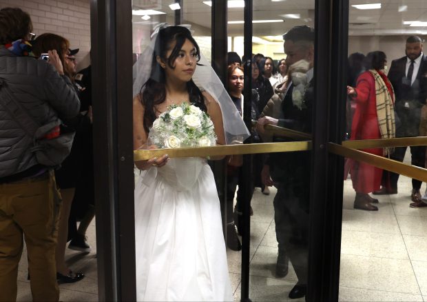 Dozens of couples wait in line with family and friends to exchange wedding vows on Valentine's Day at City Hall on Feb. 14, 2025, in Chicago. (Antonio Perez/Chicago Tribune)