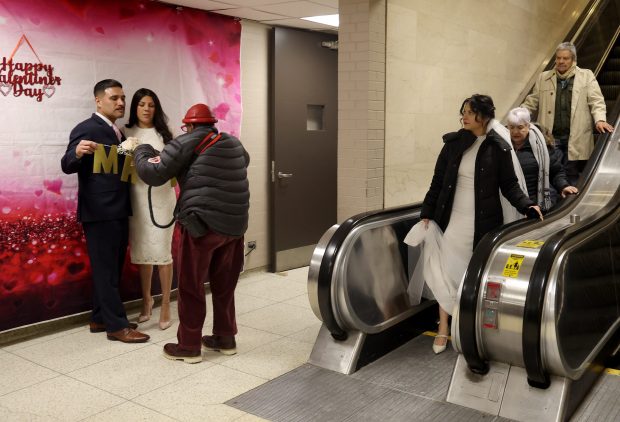 Couples arrive at City Hall to get married and take photos with a Valentine's Day backdrop on Valentine's Day in Chicago, Feb. 14, 2025. (Antonio Perez/Chicago Tribune)