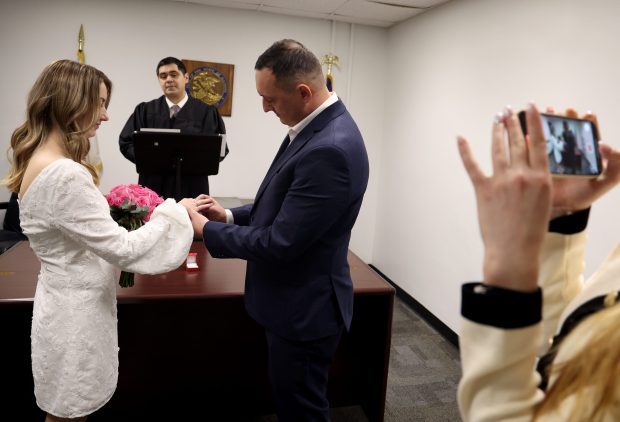 Anna and Vitaliy Hafych exchange wedding vows in front of Judge Pedro Fiegoso on Valentine's Day at City Hall on Feb. 14, 2025. (Antonio Perez/Chicago Tribune)