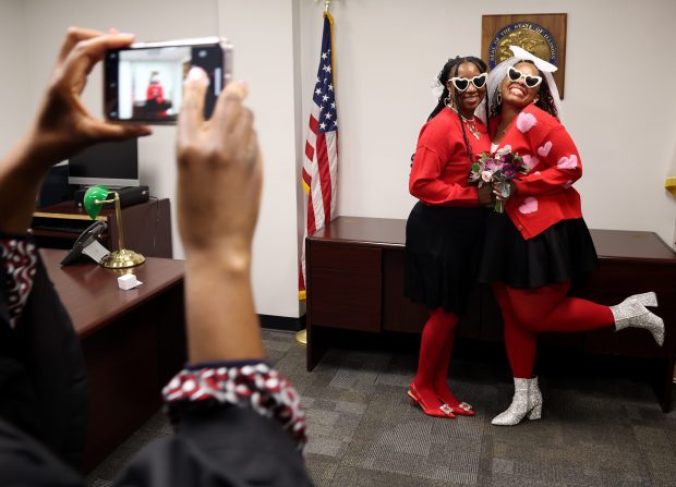 Teela Williams, left, and Orlanda Sanders pose for photos after exchanging wedding vows with Judge Linda Sackey on Valentine's Day at City Hall, Feb. 14, 2025. (Antonio Perez/Chicago Tribune)