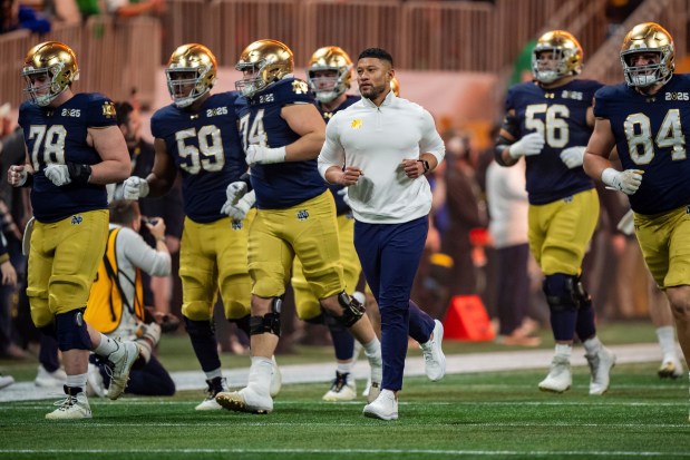 Notre Dame coach Marcus Freeman runs onto the field with his players before the College Football Playoff national championship game against Ohio State on Jan. 20, 2025, in Atlanta. (AP Photo/Jacob Kupferman)