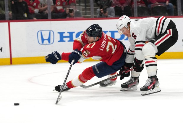 Florida Panthers center Eetu Luostarinen (27) shoots on the goal as Chicago Blackhawks' Connor Murphy, right, defends during the second period of an NHL hockey game, Saturday, Feb. 1, 2025, in Sunrise, Fla. (AP Photo/Lynne Sladky)