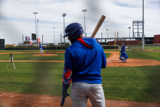 Cubs outfielder Alexander Canario waits to hit while pitcher Justin Steele throws to center fielder Pete Crow-Armstrong at live batting practice during spring training on Feb. 13, 2025, at Sloan Park in Mesa, Ariz. (Armando L. Sanchez/Chicago Tribune)