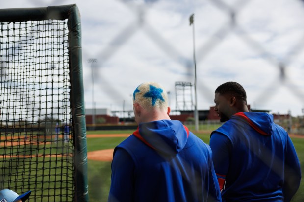 Cubs center fielder Pete Crow-Armstrong, left, and outfielder Alexander Canario stand near the side of a practice field after hitting at live batting practice during spring training on Feb. 13, 2025, at Sloan Park in Mesa, Ariz. (Armando L. Sanchez/Chicago Tribune)