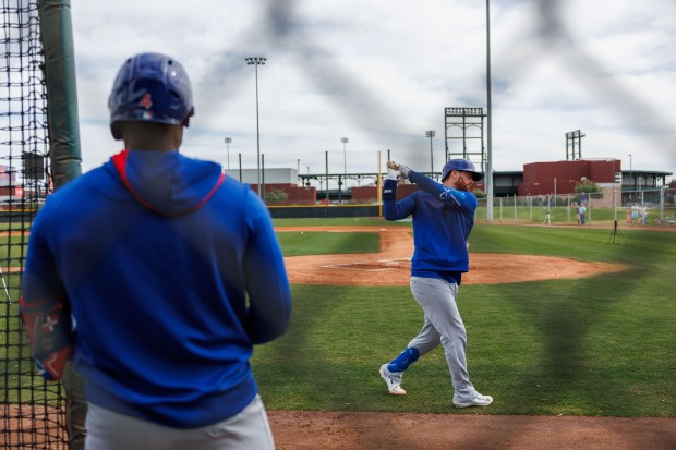 Cubs outfielder Alexander Canario watches catcher Carson Kelly warm up before hitting during spring training on Feb. 13, 2025, at Sloan Park in Mesa, Ariz. (Armando L. Sanchez/Chicago Tribune)