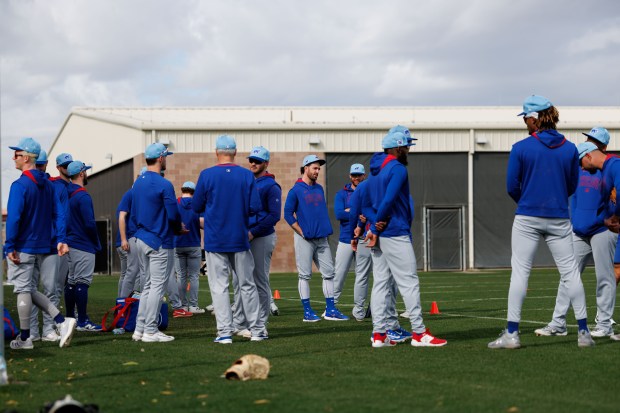 Chicago Cubs players talk before warming up on the first day of full-squad workouts during spring training at Sloan Park Friday Feb. 14, 2025, in Mesa, Ariz. (Armando L. Sanchez/Chicago Tribune)