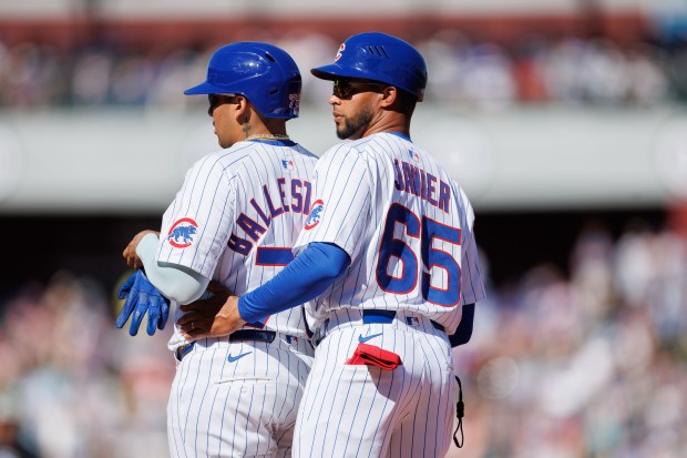 Cubs first-base coach Jose Javier, right, talks with designated hitter Moisés Ballesteros after he was walked during the third inning against the White Sox on Feb. 22, 2025, at Sloan Park in Mesa, Ariz. (Armando L. Sanchez/Chicago Tribune)