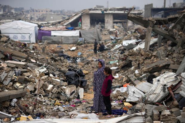 The Rehan family in their encampment in the ruins of their home amid widespread destruction caused by the Israeli military's ground and air offensive in Jabaliya, Gaza Strip, Monday, Feb. 10, 2025. (AP Photo/Abdel Kareem Hana)