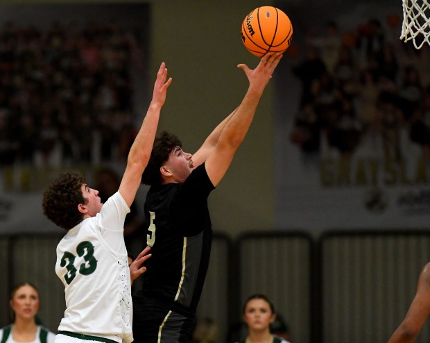 Grayslake North's Uros Mitrovic goes for a layup past Grayslake Central's Mitchell Ross 