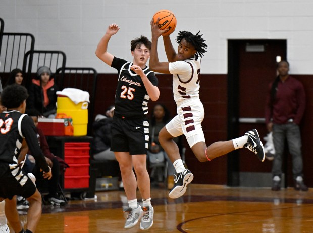 Zion's Maurice Thompson, right, keeps the ball away from Libertyville's Jack Cenar during their boys basketball game at Zion, on Friday, Jan. 10, 2025. (Michael Schmidt / for the News-Sun)