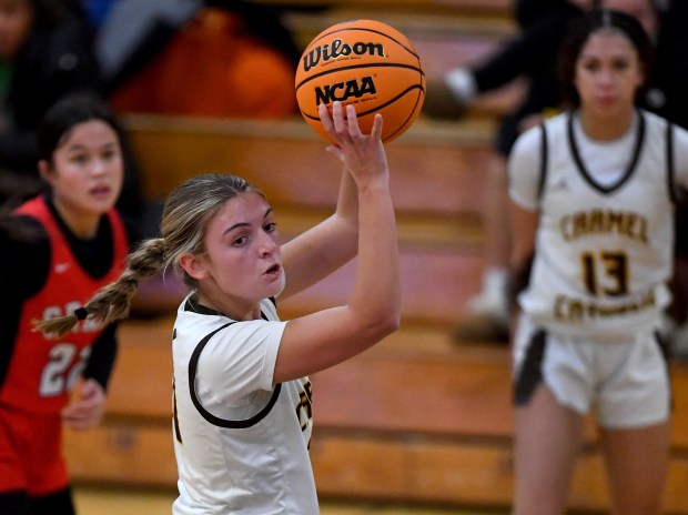 Carmel's Maron Bowes (21) takes the ball at the top of the key before passing it during the Class 4A Round Lake Regional semifinal, on Monday Feb. 17, 2025. (Rob Dicker / for the News Sun)