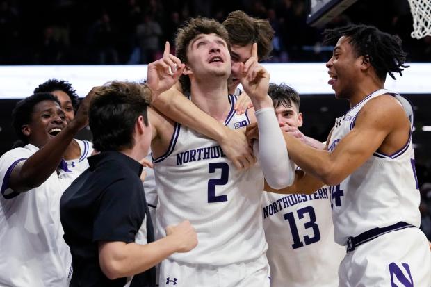 Northwestern forward Nick Martinelli (2) celebrates with teammates after scoring the winning basket during overtime of an NCAA college basketball game against Maryland in Evanston, Ill., Thursday, Jan. 16, 2025. (AP Photo/Nam Y. Huh)