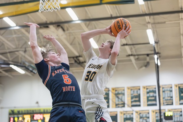 Neuqua Valley's Mason Martin goes for a layup against Naperville North's Max Steele