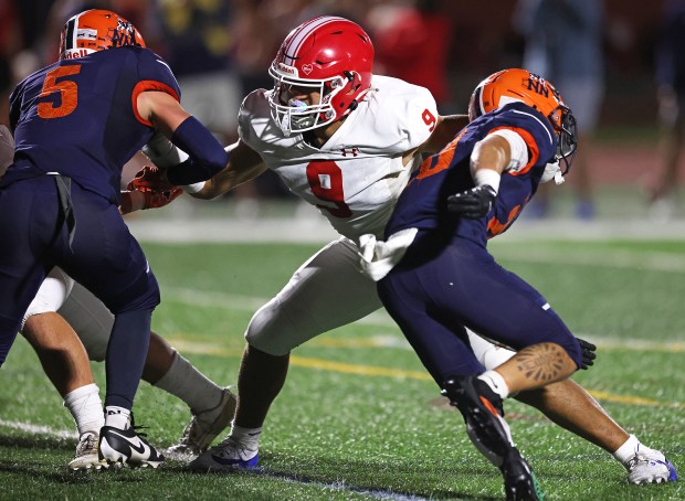 Naperville Central's Jake Stanish blocks Naperville North's Aiden Drendel and Zach Mally