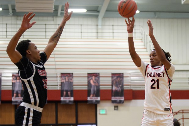 Calumet guard Johnnie Hudson, on right, shoots for three past 21st Century forward Elijah Musaddiq during their game on Monday, Jan. 13, 2025. (Kyle Telechan/for the Post-Tribune)