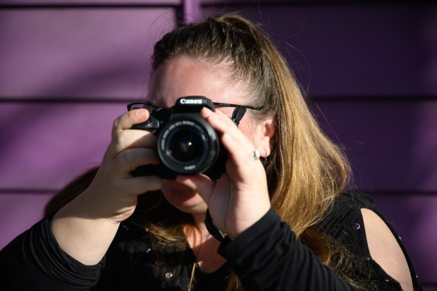 Gary filmmaker Jessica Renslow, who will debut her short film "Method: A Voice Actor Prepares" on Wednesday, raises the camera that she uses to film her work to her eye as she poses for a photo outside of her home on Monday, Feb. 10, 2025. (Kyle Telechan/for the Post-Tribune)