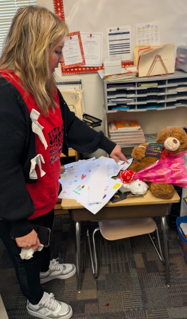 Bailey Elementary second grade teacher Linda Scartozzi points to drawings and notes students left on Aurorah Payne's desk on Monday. (Carole Carlson/Post-Tribune)