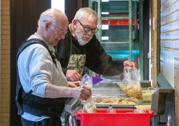 James Scheuer, left, and Mark Schilling bag cooked pierogis at the St. Josaphat Ukrainian Catholic Church in Munster, Indiana on Friday, Feb. 21, 2025. Scheuer, of Lake Station, and Schilling, of Whiting, joined many other volunteers helping create, cook and package for the weekly pierogi sale at the church. (Andy Lavalley for the Post-Tribune)