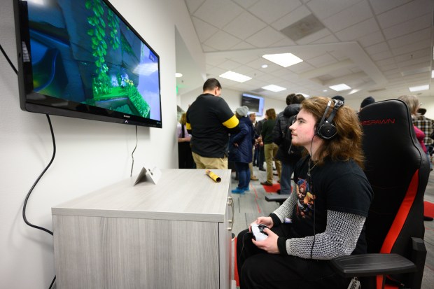 Class of 2024 graduate Zion Gifford, who took a class in RPG writing under Professor Martin Buinicki, plays Playstation 5 game Astro Bot during the grand opening of the school's Center for Games and Interactive Entertainment on Tuesday, Feb. 4, 2025. (Kyle Telechan/for the Post-Tribune)