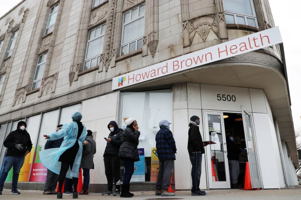 People line up outside Howard Brown Health on East 55th Street at Lake Park Avenue in Chicago to be tested for the COVID-19 virus on Dec. 22, 2021. (Terrence Antonio James/Chicago Tribune)